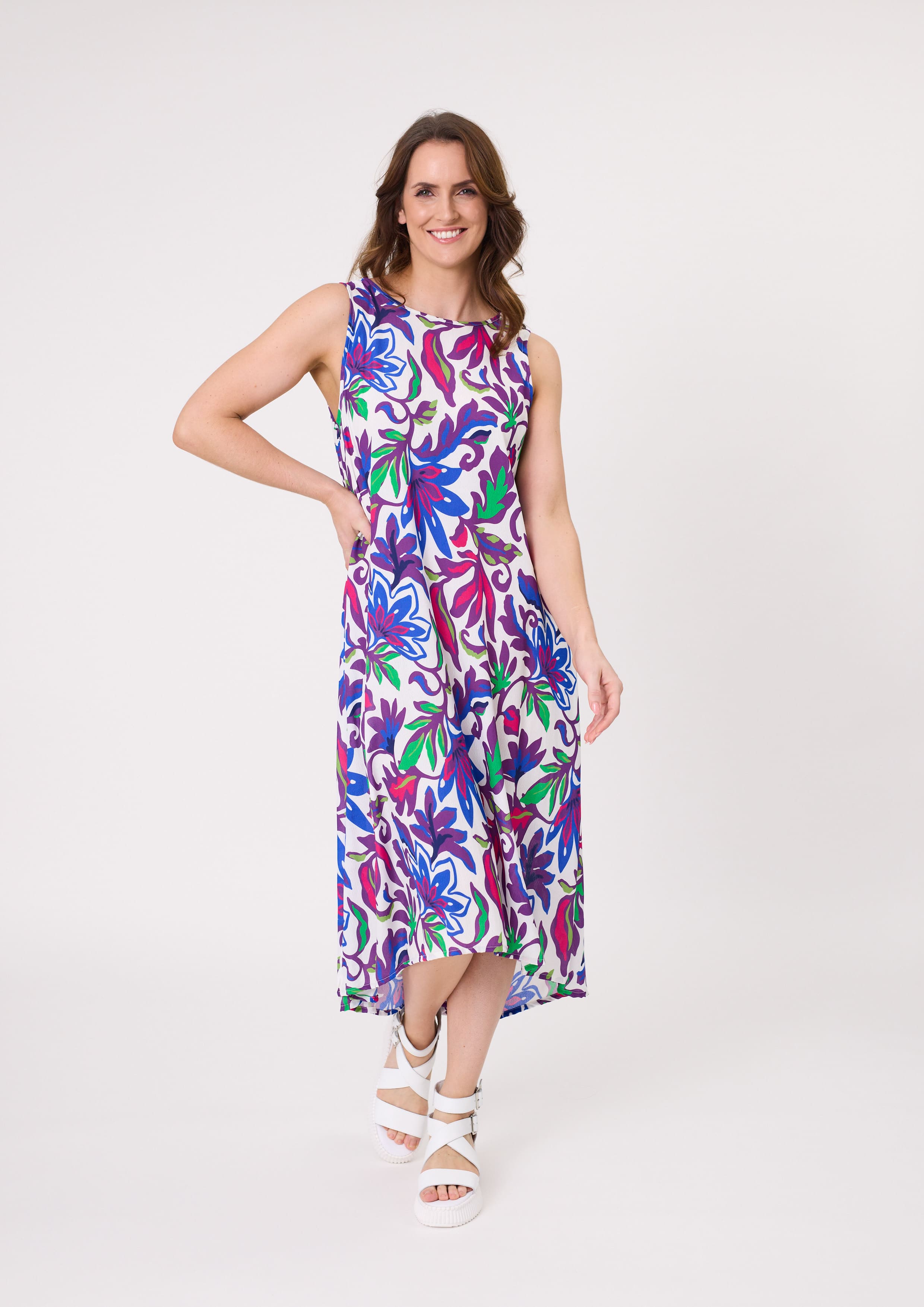 Ana Dress with bold floral print in blue, green, purple, and cerise, featuring a sleeveless midi silhouette and hidden pockets, made from a soft, breathable rayon-viscose blend.