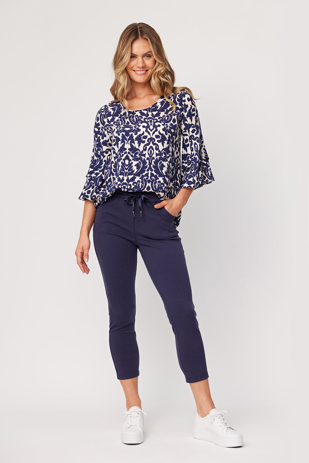 Gemma Pant in navy with a slim, ankle-length cut, elasticated waistband with satin ties, and side and back pockets, made from a soft cotton-viscose blend.
