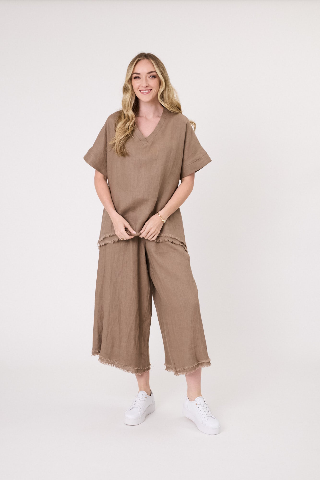 Carola Linen Top in mocha with a relaxed fit, V-neckline, short sleeves, and frayed hem, made from breathable linen for warm-weather comfort.