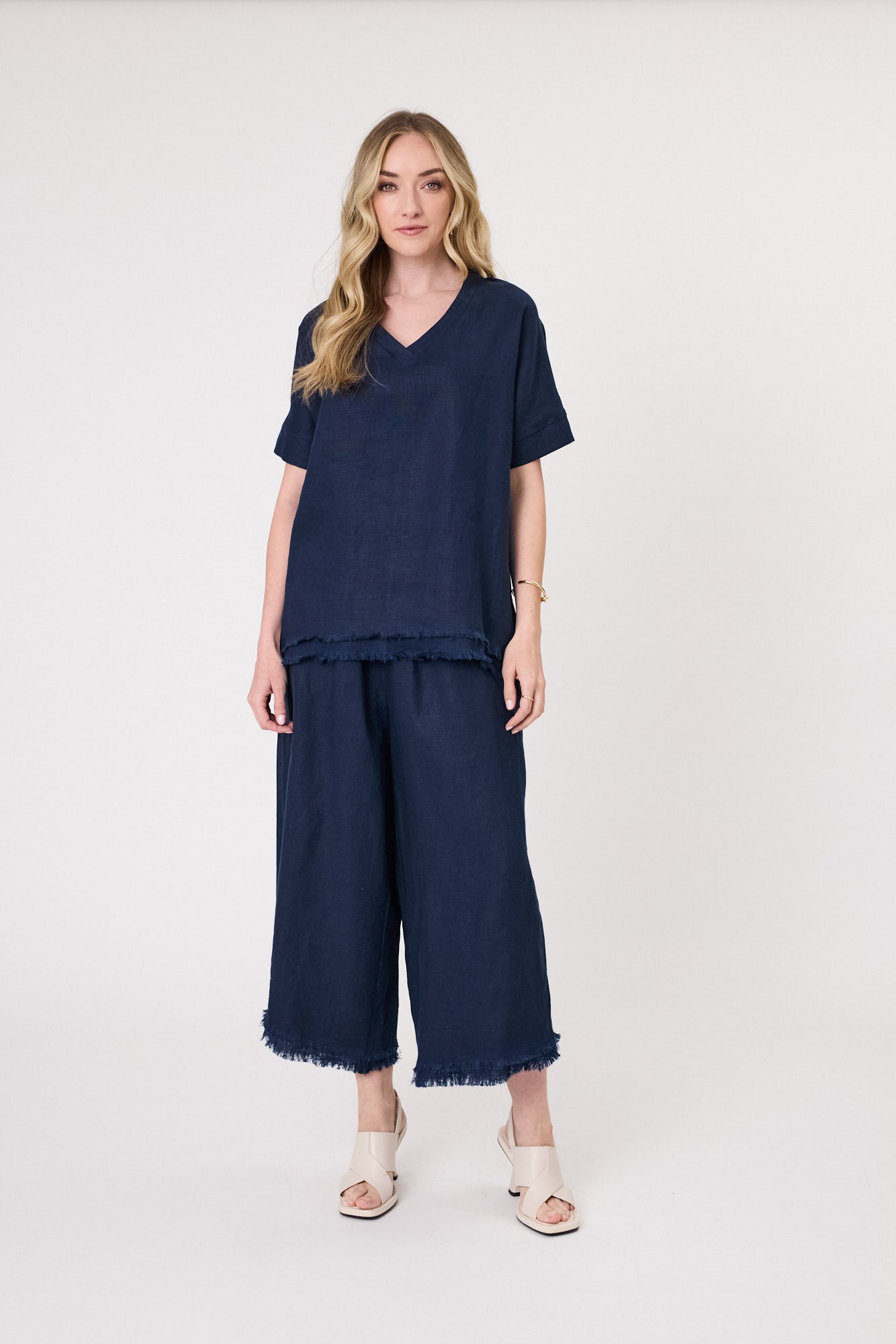 Carola Linen Top in navy with a relaxed fit, V-neckline, short sleeves, and frayed hem, made from breathable linen for warm-weather comfort.