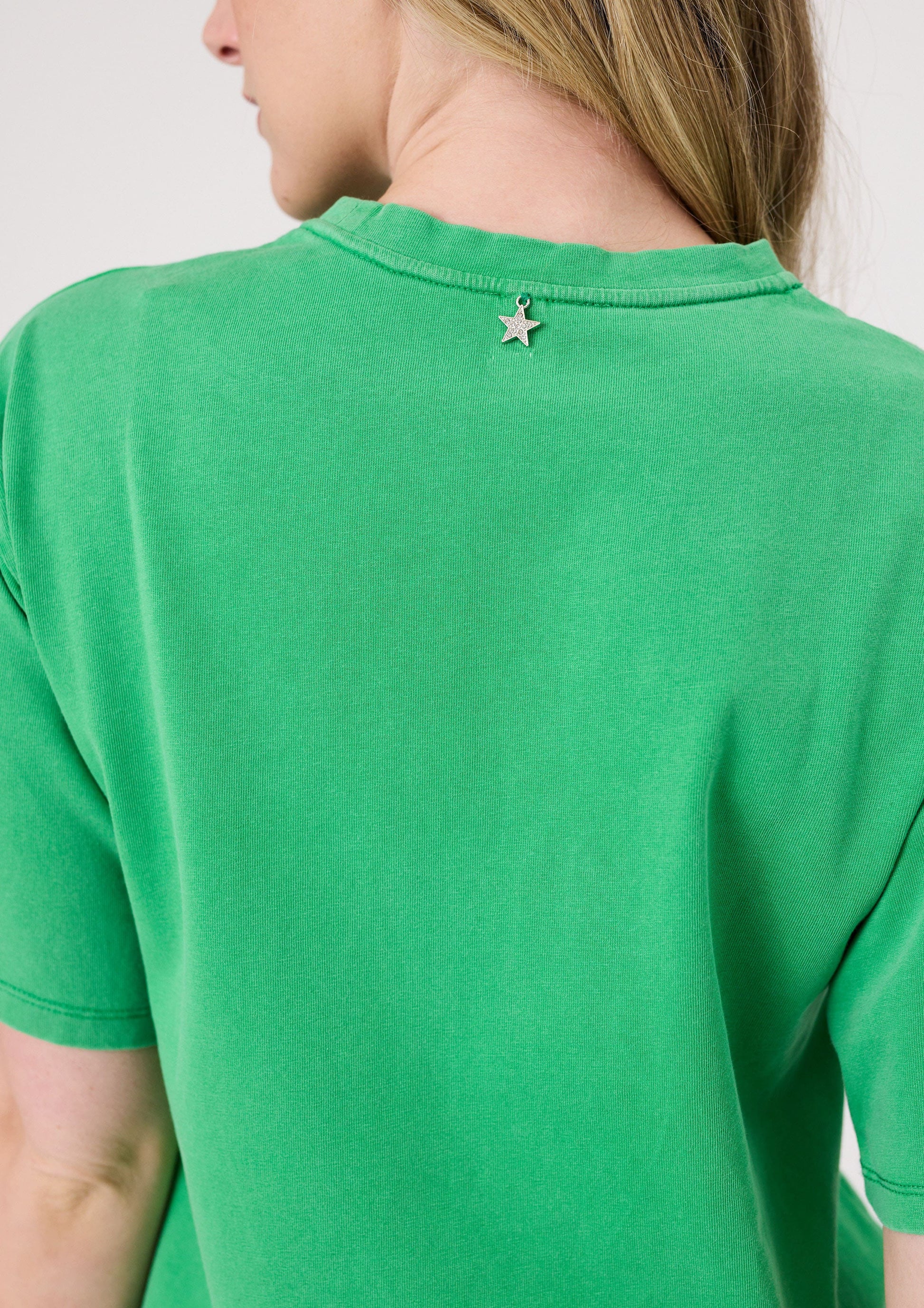 Back view of green Los Angeles Tee featuring a silver star charm detail on the back collar.