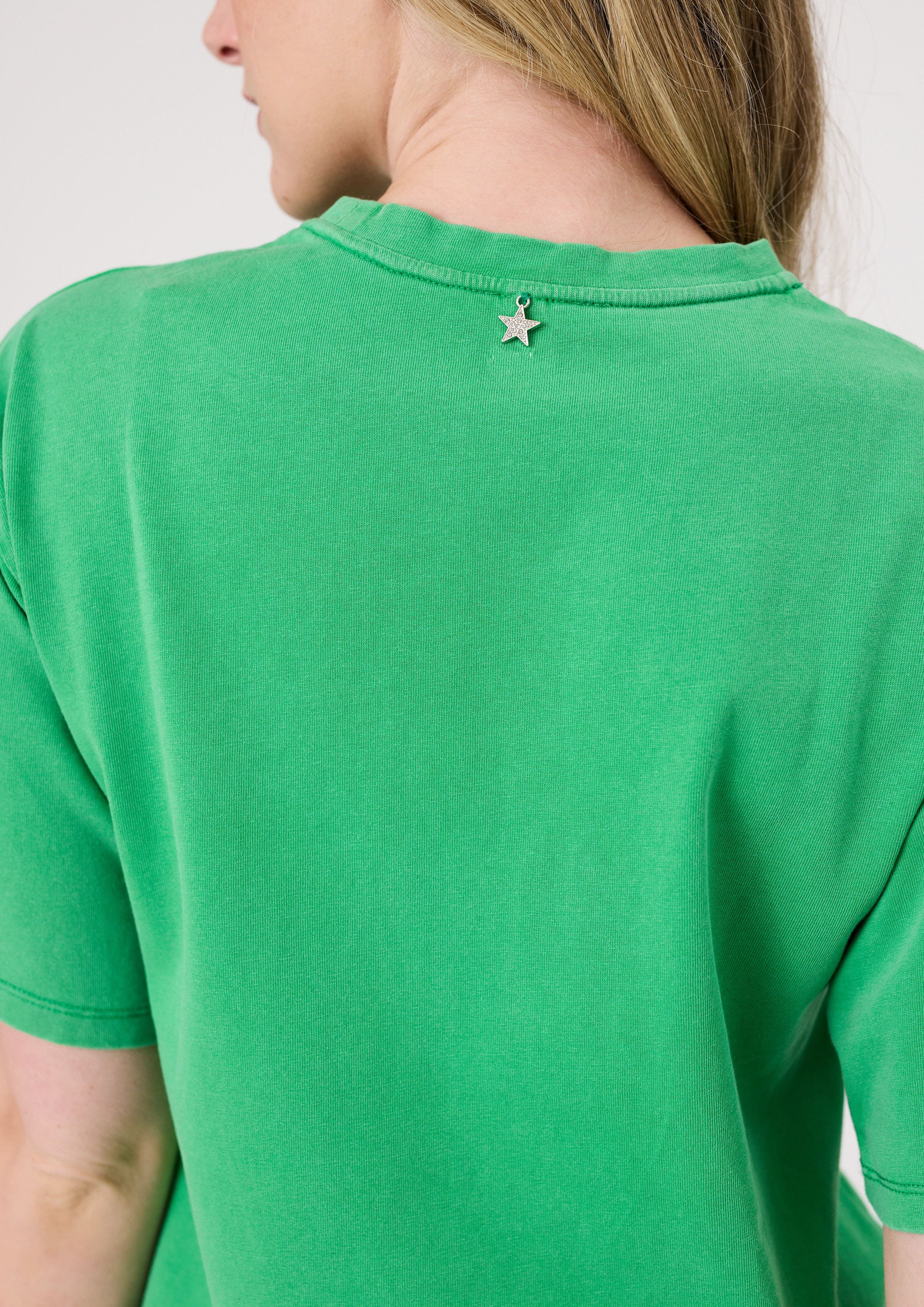 Back view of green Los Angeles Tee featuring a silver star charm detail on the back collar.