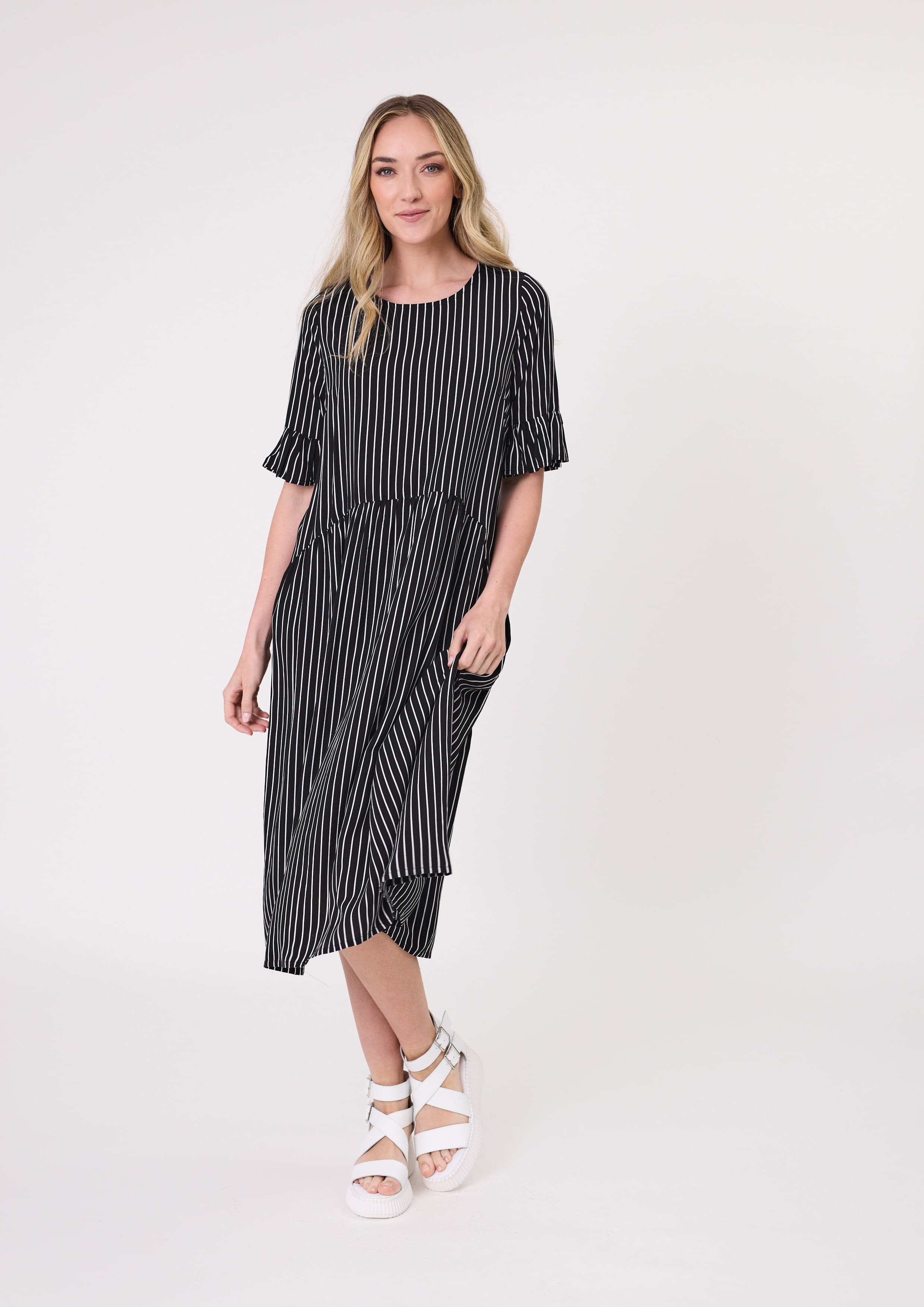 Madonna Dress in black and white stripe with frill sleeves, midi length, and side pockets, made from a breathable rayon-viscose blend.