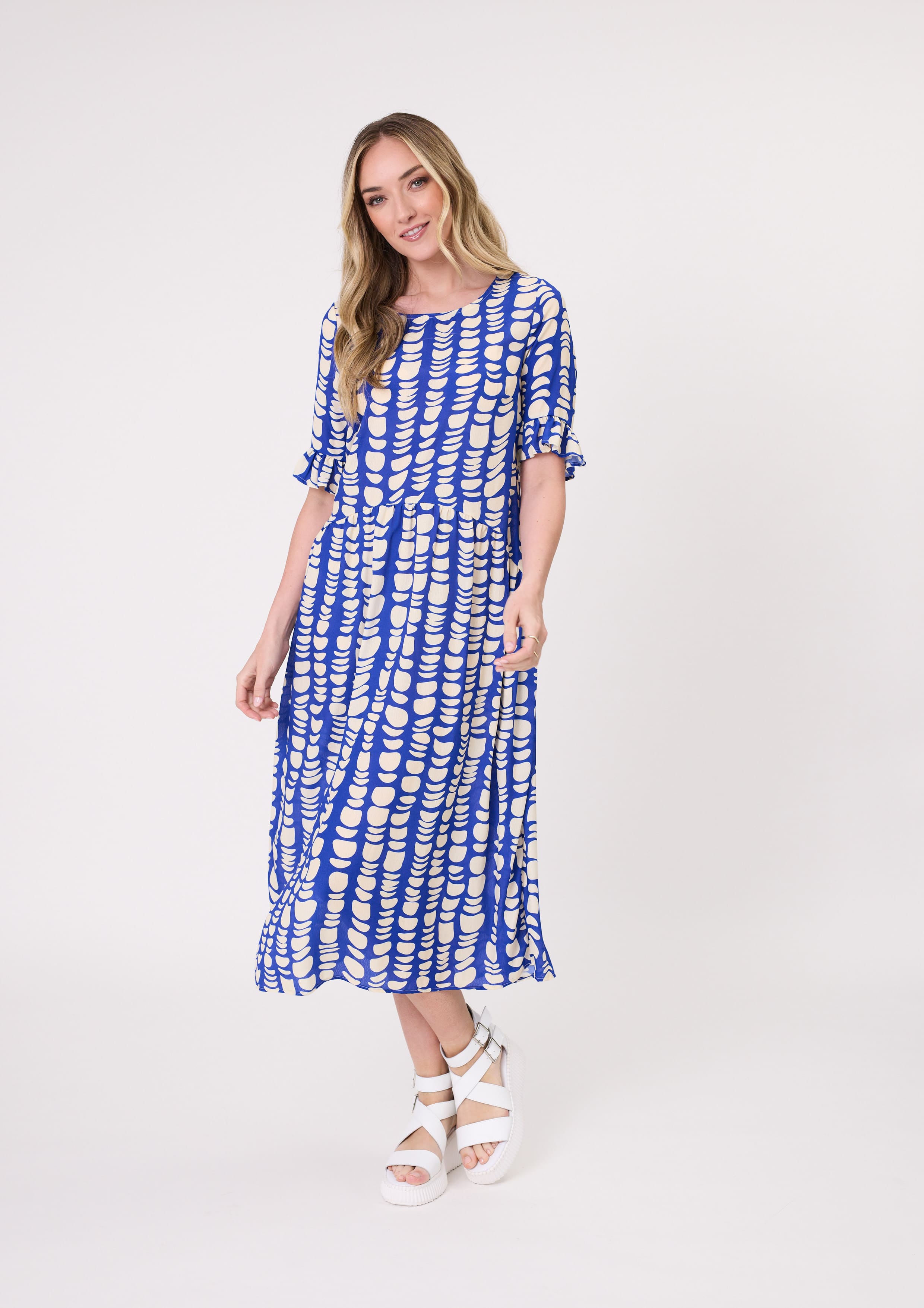 Madonna Dress in vibrant cobalt blue and white print with delicate frill sleeves, flattering midi length, and side pockets, made from a breathable rayon-viscose blend.