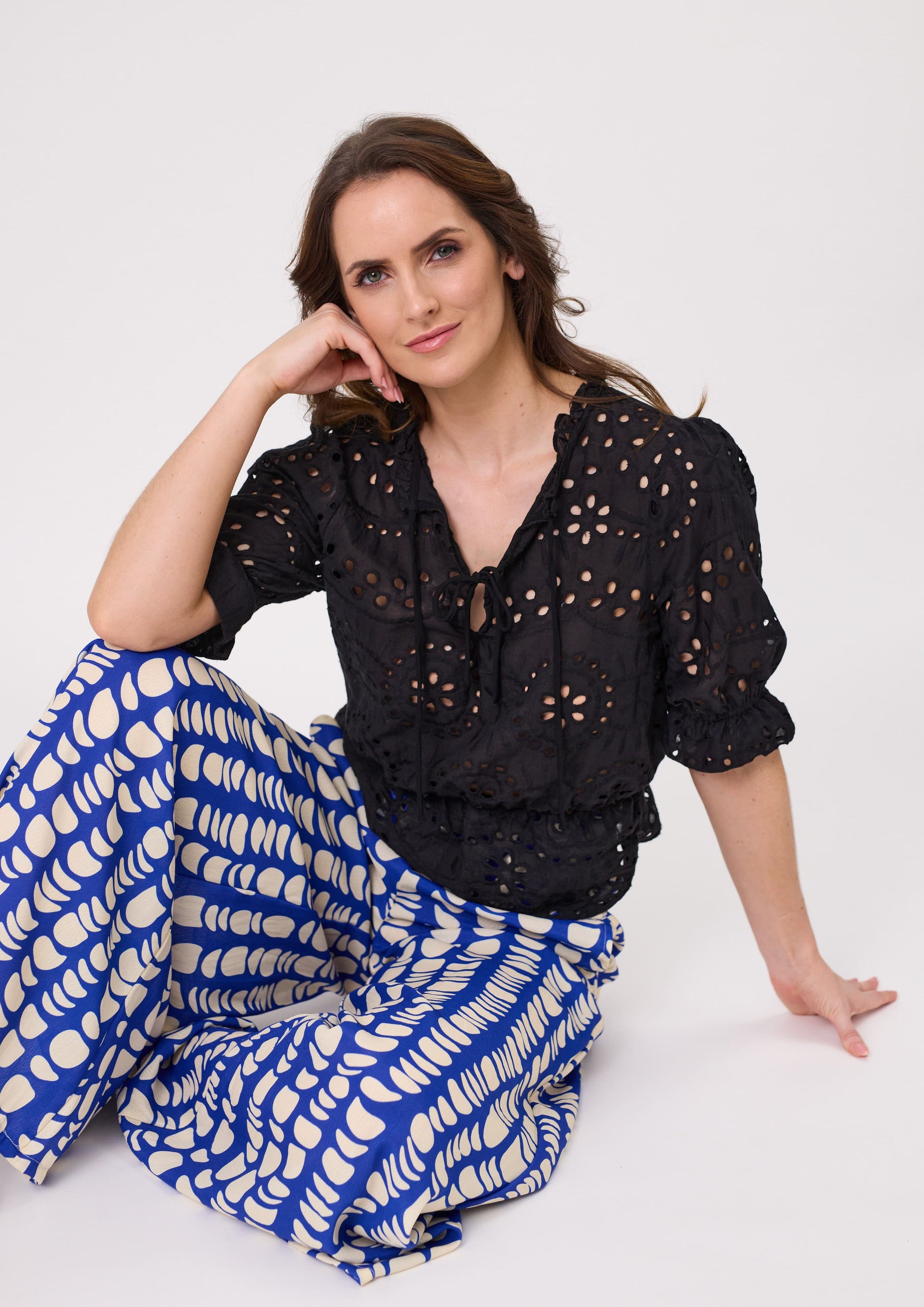 Milana Lace Top in black with a delicate lace-style finish, featuring short sleeves and a flattering peplum hem, made from 100% cotton for breathable comfort.