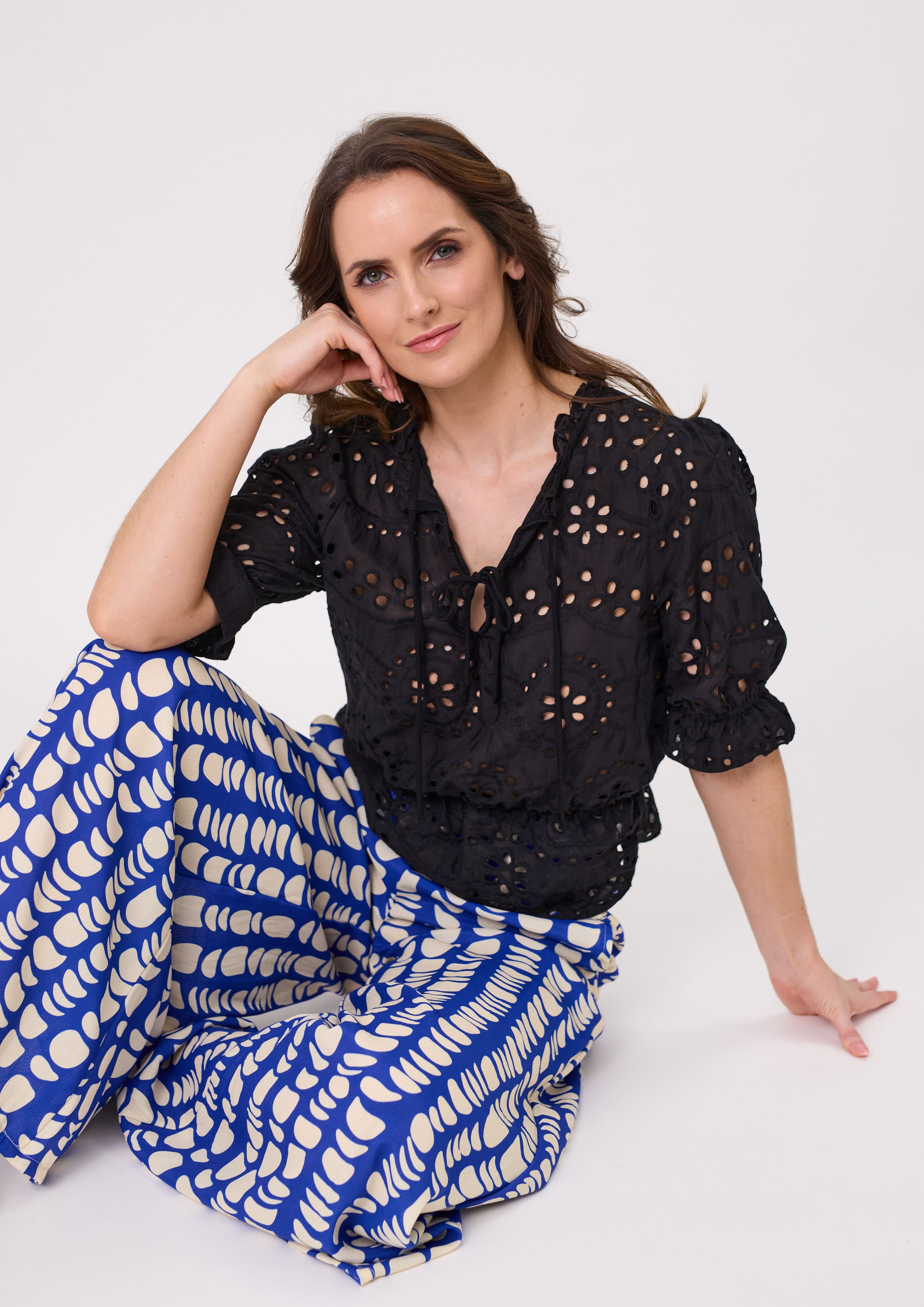 Milana Lace Top in black with a delicate lace-style finish, featuring short sleeves and a flattering peplum hem, made from 100% cotton for breathable comfort.