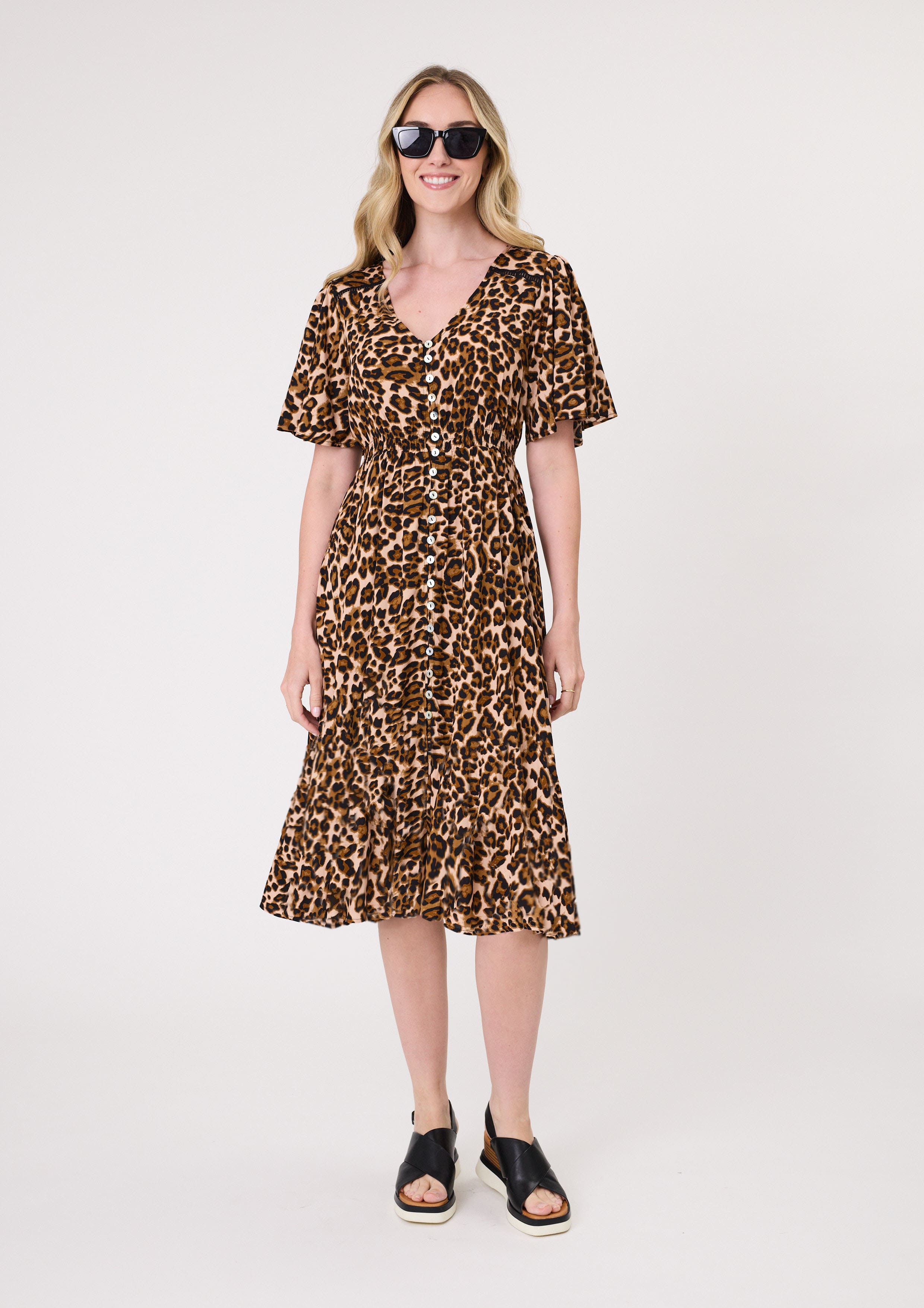 Vittoria Dress in an all-over leopard print with a flattering V-neckline, short sleeves, button-down front, and a lightly frilled hem for a feminine finish.